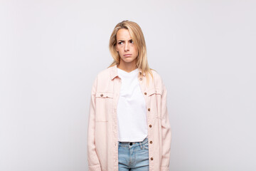  feeling sad, upset or angry and looking to the side with a negative attitude, frowning in...