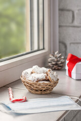 Fototapeta na wymiar Traditional Austrian and German crescent-shaped Christmas pastries - Vanillekipferl - on the windowsill near the window with Christmas decorations