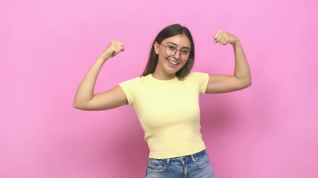 Young caucasian woman showing strength gesture with arms, symbol of feminine power