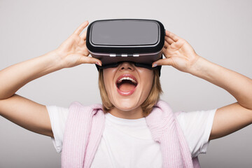 Close up photo of a blonde woman with vr headset gesturing surprisement on a white studio wall