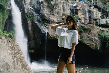Stylish woman enjoying view of waterfall