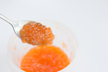  Red caviar on a metal spoon close-up. Concept for Christmas and New Year festive dishes. Healthy natural red salmon caviar