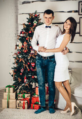 beautiful and loving couple near the christmas tree