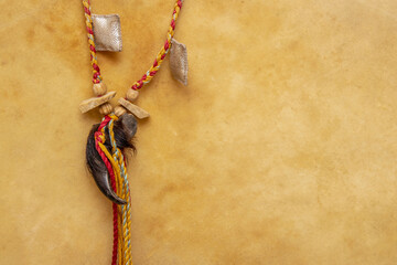 Shamanic amulet around the neck. Bear claw. Braided colored threads.