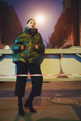 Woman in night city with road signs and stripe