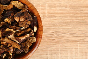 Dried mushrooms in wooden bowl. Boletus badius.