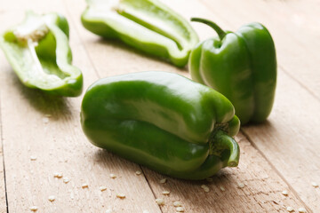 Green bell pepper on wooden rustick table. Close up view.