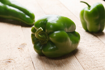 Green bell pepper on wooden rustick table. Close up view.