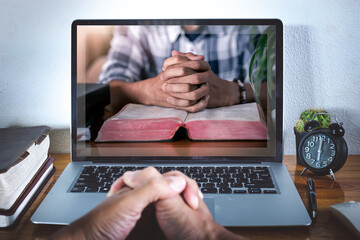 Hands praying on bible with computer laptop, Online live church for sunday service, Home church...