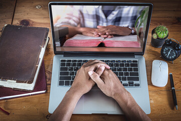 Hands praying on computer laptop, Online live church for sunday service, Home church during...