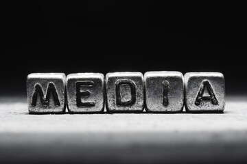 Conceptual inscription media on metal cubes on a black gray background close-up isolated