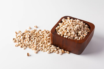 Job's tears in a wooden cup on a white background