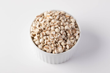 Job's tears in a white ceramic cup on a white background.