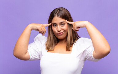young blonde woman with a serious and concentrated look, brainstorming and thinking about a...