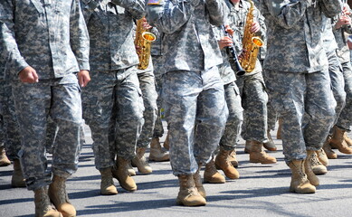 USA army marching band in a parade outdoors.