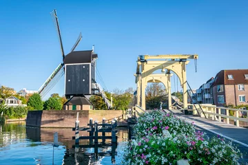 Fotobehang Classic dutch scene with drawbridge and windmill in the city of Leiden, Holland © Menyhert