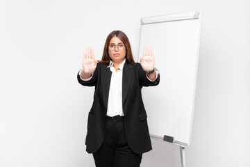  looking serious, unhappy, angry and displeased forbidding entry or saying stop with both open palms