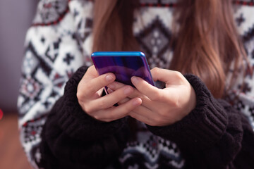 Fototapeta premium Christmas discounts. Girl chooses gifts on a mobile phone