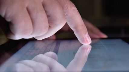 Hand using tablet screen with growth of financial stock report.