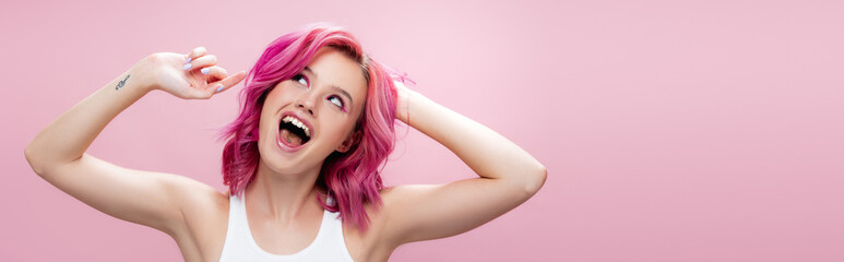 excited young woman touching colorful hair isolated on pink, panoramic shot