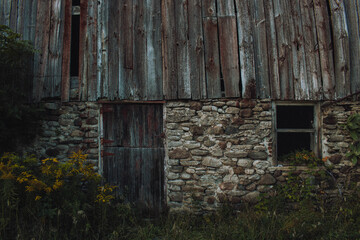 Fototapeta na wymiar red barn, with a stone base and door
