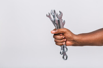 African american man's hand holding a spanners or wrench isolated on white background. Close up...