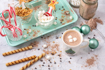Hot Cocoa Bar with Christmas Cups and Decorations; Multiple Toppings Pictured; White and Gray Countertop