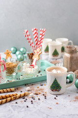Hot Cocoa Bar with Christmas Cups and Decorations; Multiple Toppings Pictured; White and Gray Countertop