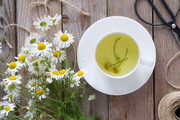 Cup of chamomile tea on wooden table