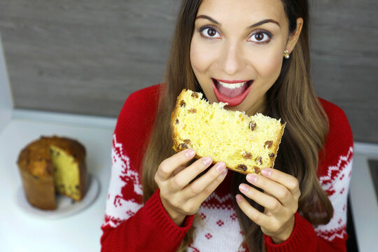 Close Up From Above Of Young Woman Eating A Slice Of Panettone Traditional Italian Cake For Christmas With Raisins And Candied Fruits