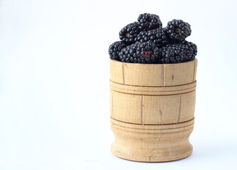 Blackberry in a wooden bowl on a white background - 381959687