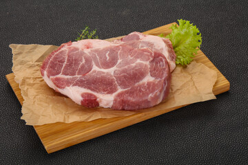 Raw pork steak over wooden board