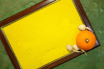Frame with yellow paper blank space for text and pumpkin on the green background. List for recording. Copy space