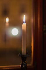 background with reflection of candles in the window, in the evening