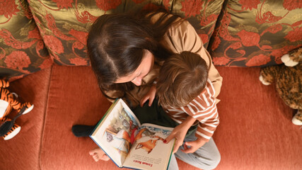 mom and child read a book, top view