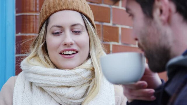 Close up of couple on date sitting outside coffee shop on busy city high street  - shot in slow motion