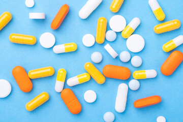Multicolor tablets and pills capsules on blue background Close-up Top view