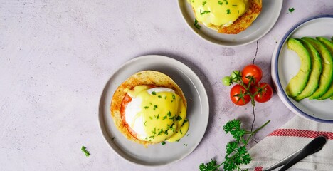Homemade  Egg Benedict with perfect poached eggs Canadian bacon topped with Hollandaise sauce,...