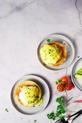 Homemade  Egg Benedict with perfect poached eggs Canadian bacon topped with Hollandaise sauce, selective focus