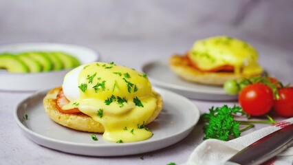 Homemade  Egg Benedict with perfect poached eggs Canadian bacon topped with Hollandaise sauce, selective focus