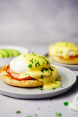 Homemade  Egg Benedict with perfect poached eggs Canadian bacon topped with Hollandaise sauce,...