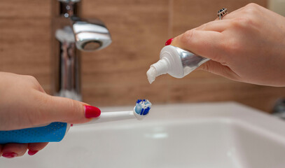 Toothpaste Toothbrush Blurred Background Squeezing Paste From Tube To Toothbrush Oral hygiene. Clean teeth. The crane is out of focus. Focus on toothbrush and toothpaste.