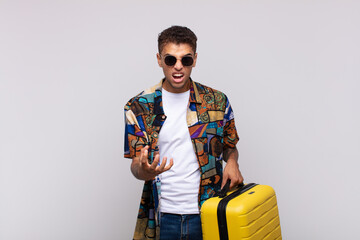 young south american man looking angry, annoyed and frustrated screaming wtf or what’s wrong with...