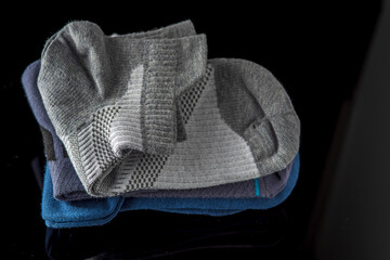 A pack of assorted men's cotton socks on a dark background.