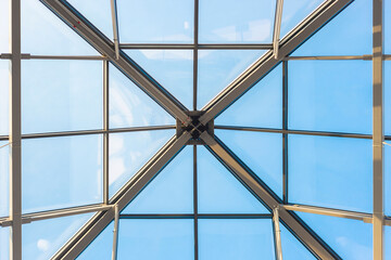 Glass ceiling in a commercial building, office or airport. Modern architecture. Blue skies and interior