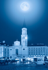 St. Michael's Church with Traditional old-fashioned phaeton at night, blue moon in the background - Vienna, Austria "Elements of this image furnished by NASA "