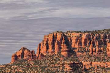 Juniper trees and a formation of  huge red sandstone rocks outside the city of Sedona, Arizona.
