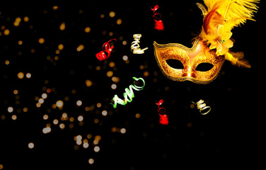 Masquerade mask on black background with sparkles. The concept of traditional holidays.