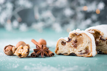 Christ stollen, traditonal christmas cake with nuts, raisons, marzipan on a blue bakcground, empty...