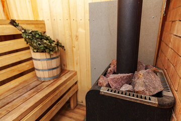Interior details Finnish sauna steam room with traditional sauna accessories basin birch broom. Traditional old Russian bathhouse SPA Concept. Relax country village bath concept.